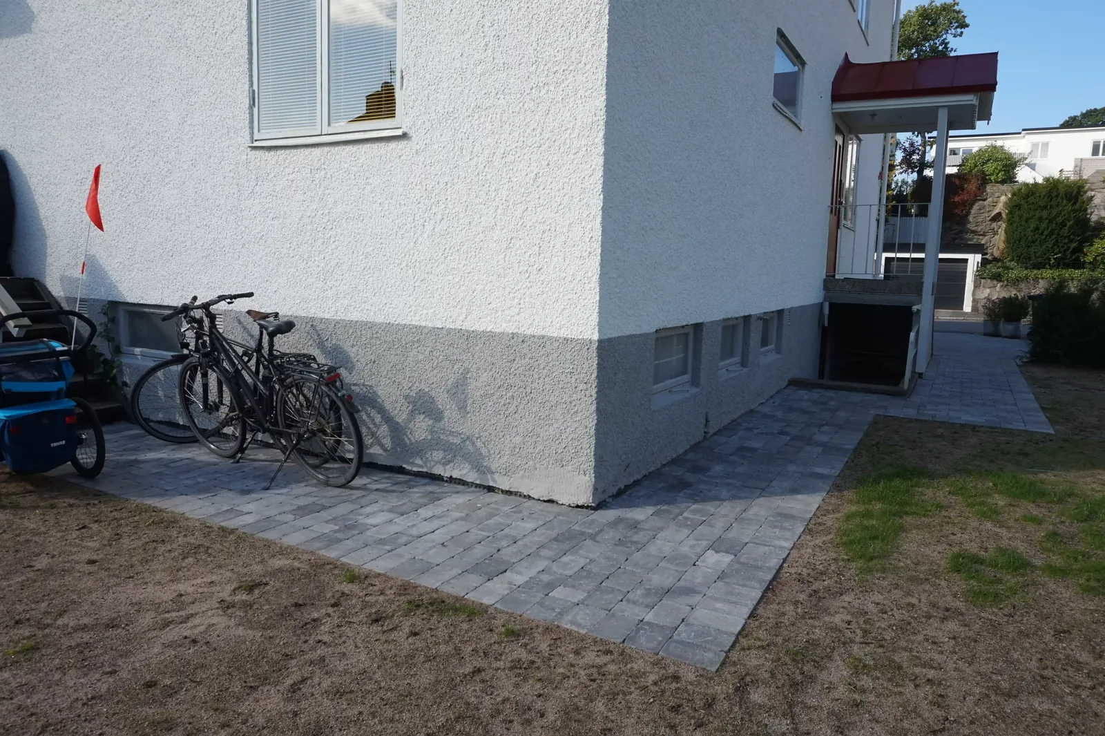 Ny stenlagd yta för cyklar längs husets sockel