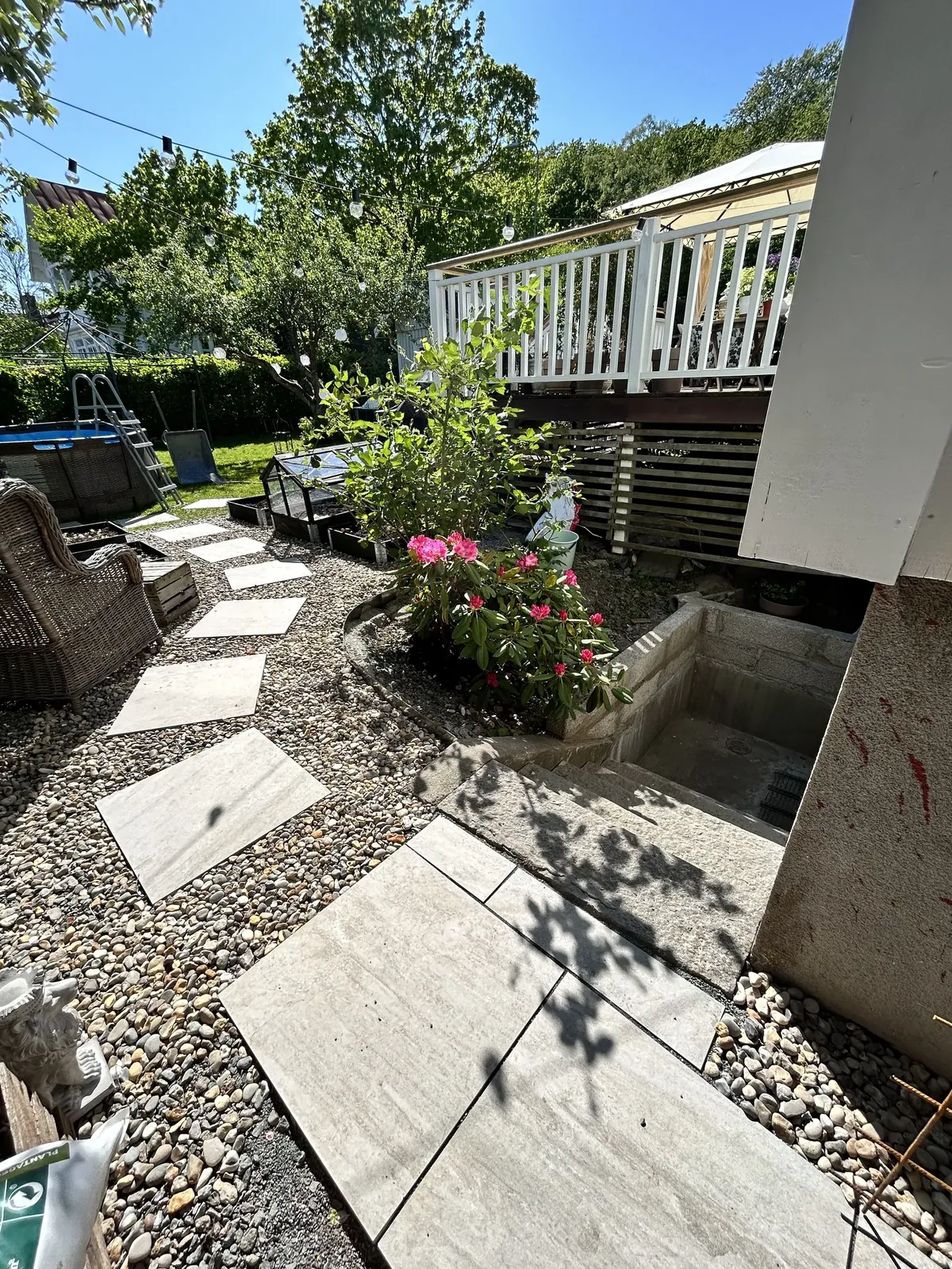 Nya steg i sten genom grus och planteringar vid altanen