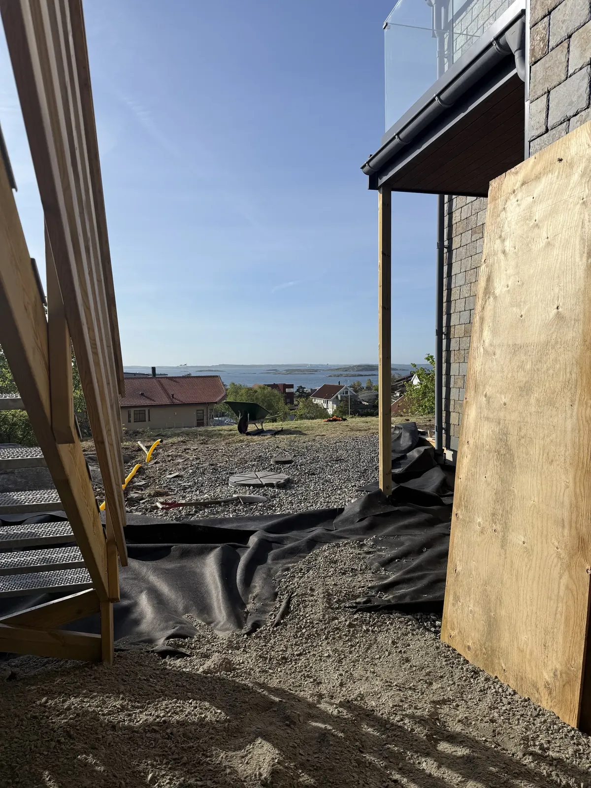 Husets sida med markduk och skivor under arbetet