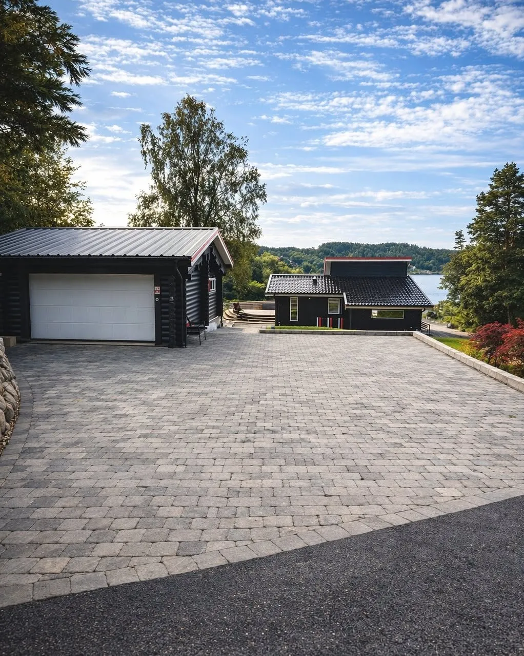 Nylagd uppfart i sten framför garage med havsutsikt