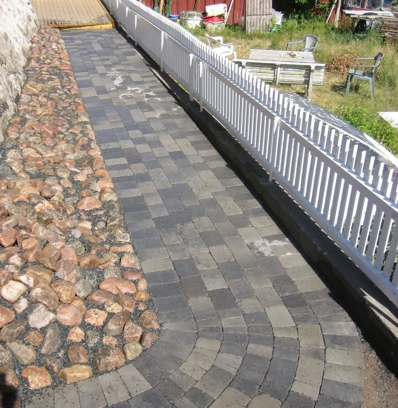 Plattläggning i mörk betongsten med kant av natursten