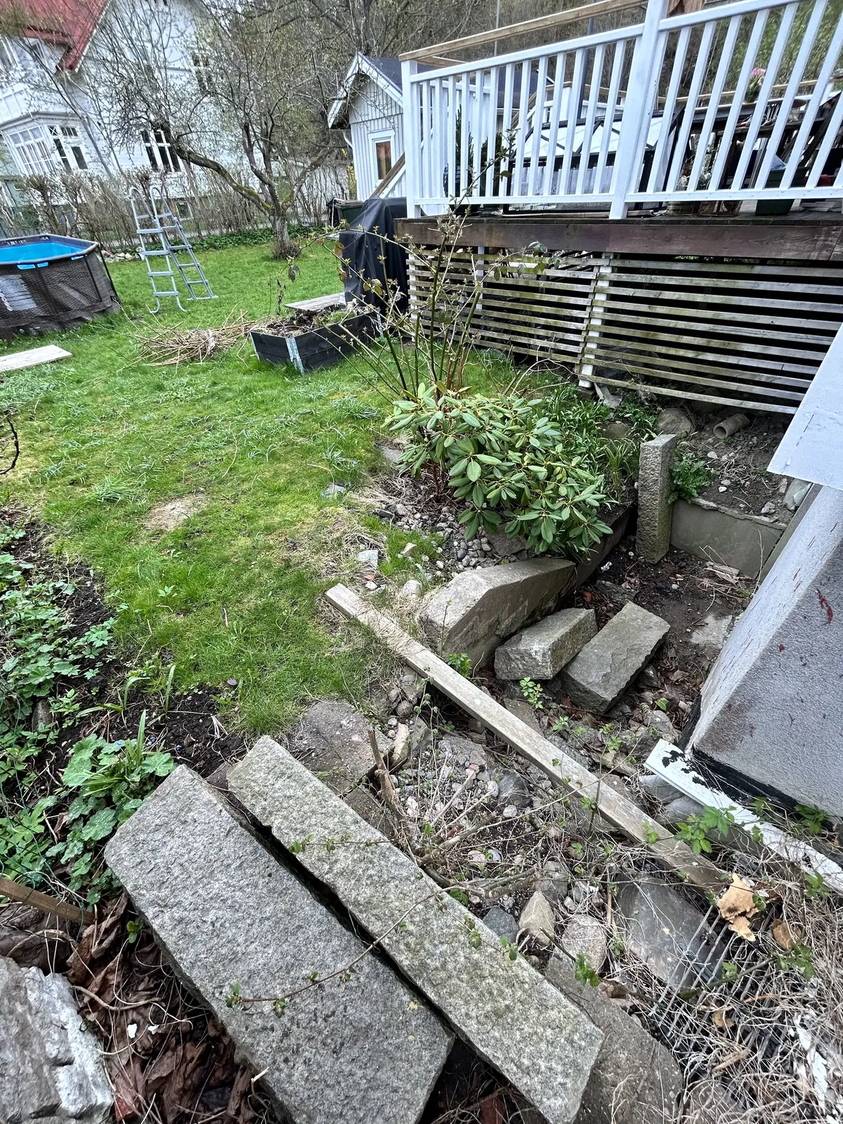 Gammal trappa och sliten trädgård vid ett hus