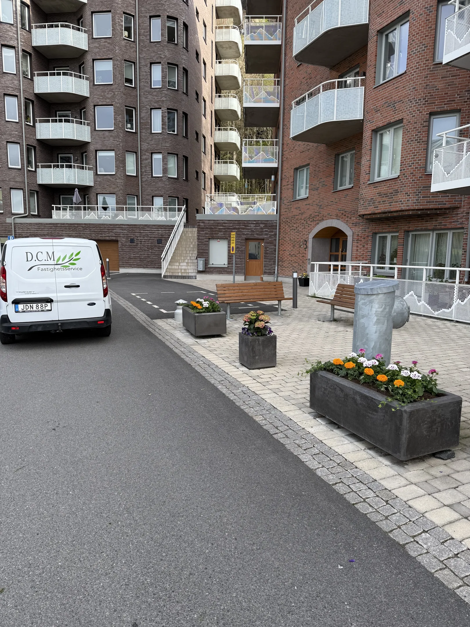 DCM:s servicebil vid en innergård med planteringskärl och bänkar