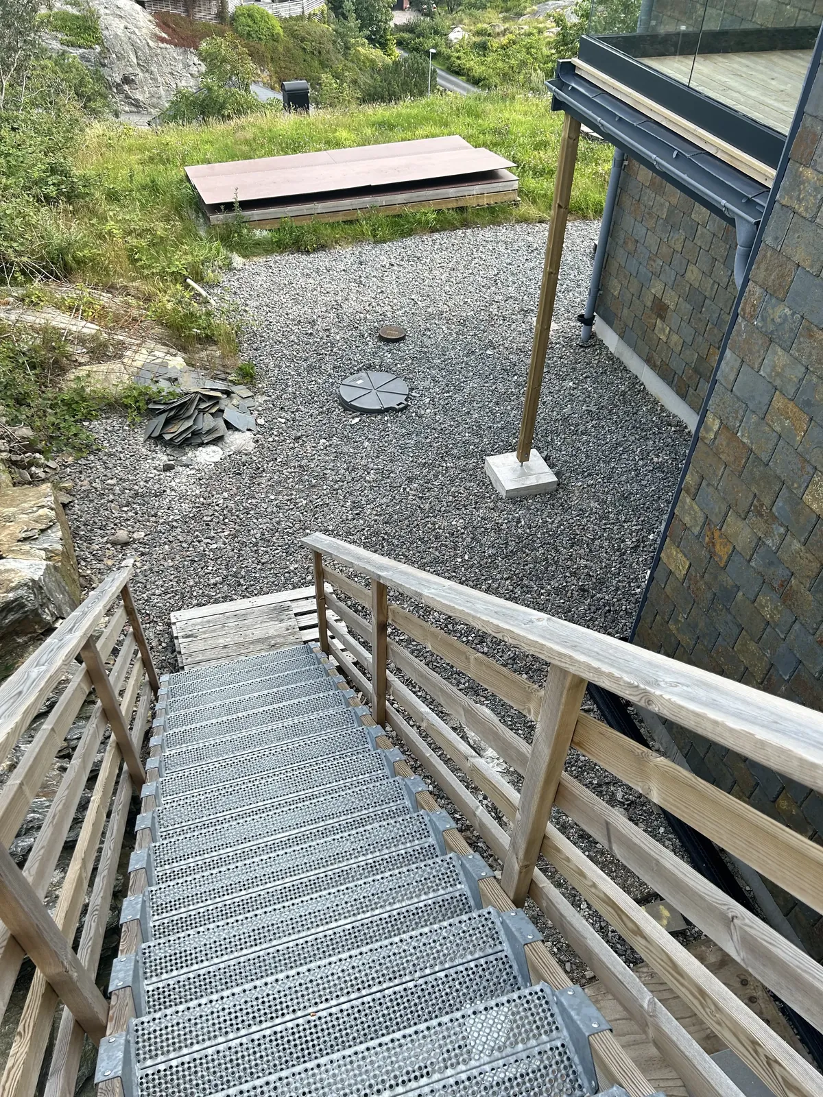 Gång i trä och grus vid ett hus i natursten innan arbetet
