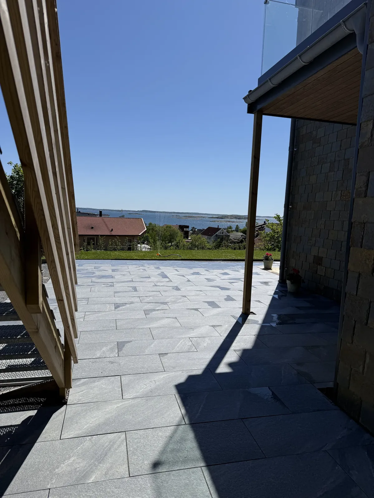 Ny plattsättning längs husets sida med havsutsikt