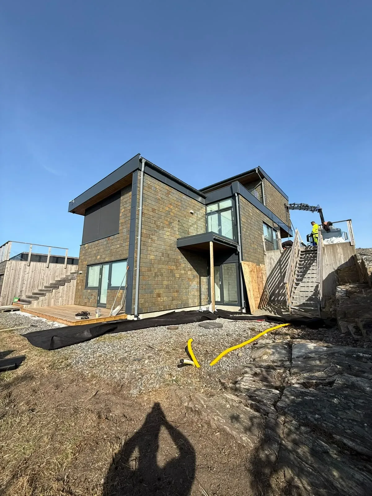 Modernt hus i natursten under markarbetet